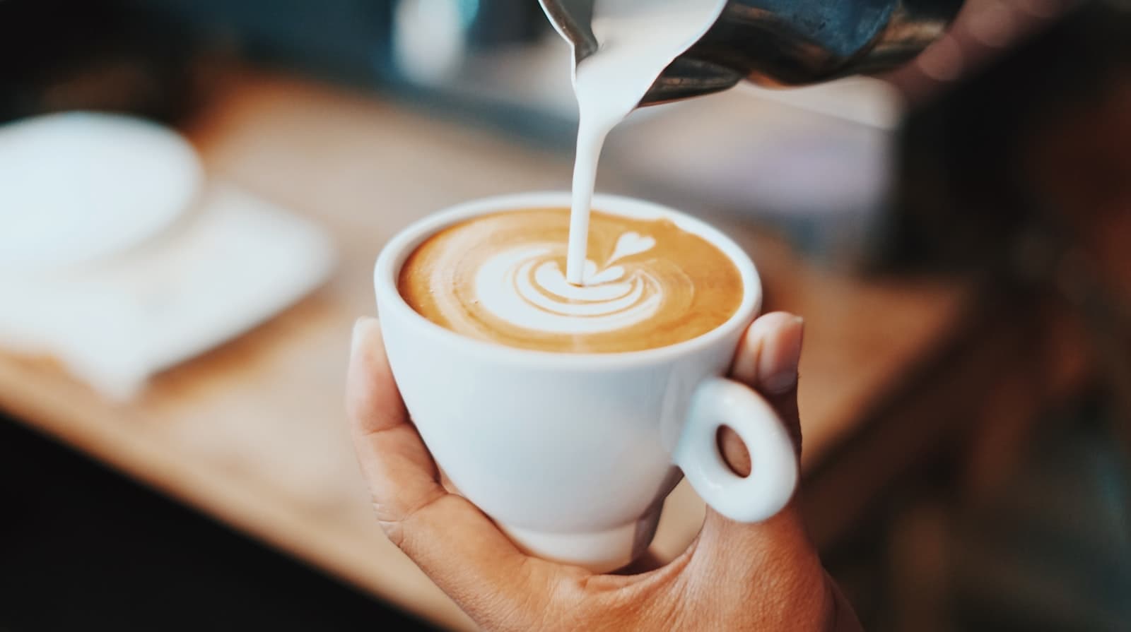Wren & Co. website hero, milk being poured into a latte